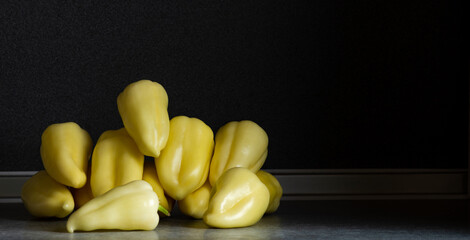 Wall Mural - Fresh yellow peppers heap on the kitchen table. Preparation for cooking.