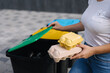 © Aleksandr - Close-up of female hold two cardboard tray of eggs. Rubbish, egg carton and thowing into recycling bins. Close-up of woman stand by blue, yeallow and open green bin