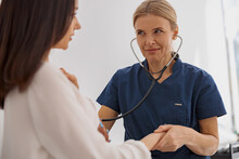 Caring Doctor Use Stethoscope Examine Patient Heart Rate And Pulse At Consultation In Hospital