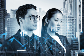 Wall Mural - Businessman and businesswoman as a SMM specialists thinking about development of social media marketing strategy to achieve business goals. Hologram icons over Bangkok background.