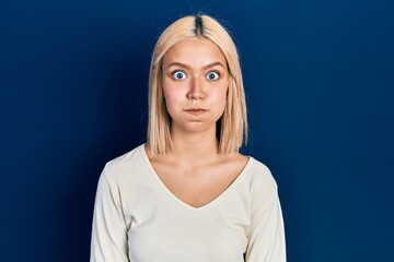 Sticker - Beautiful blonde woman wearing casual sweater puffing cheeks with funny face. mouth inflated with air, crazy expression.