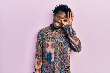 Poster - Young african american man wearing casual clothes smiling happy doing ok sign with hand on eye looking through fingers