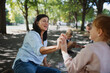 © Halfpoint - Senior couple with granddaughter drawing with chalks on pavement outdoors in park.