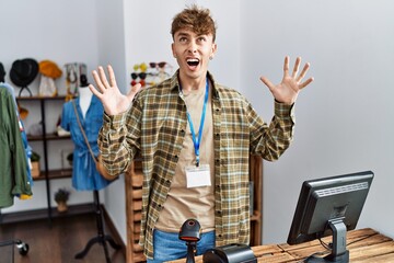 Sticker - Young caucasian man working as manager at retail boutique crazy and mad shouting and yelling with aggressive expression and arms raised. frustration concept.