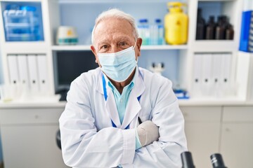 Sticker - Senior man wearing scientist uniform and medical mask with arms crossed gesture at laboratory