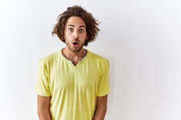 Sticker - Young hispanic man standing over isolated background afraid and shocked with surprise expression, fear and excited face.