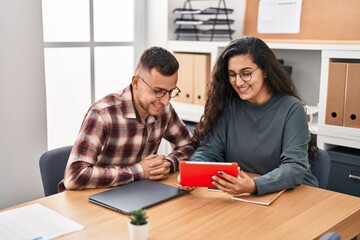 Poster - Man and woman business workers using laptop and touchpad at office