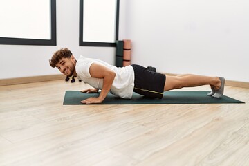 Poster - Young arab man smiling confident training abs exercise at sport center