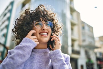 Young middle east woman smiling confident talking on the smartphone at street