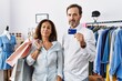 © Krakenimages.com - Hispanic middle age couple holding shopping bags and credit card relaxed with serious expression on face. simple and natural looking at the camera.