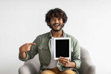 Wall Mural - Happy indian man pointing at tablet with empty screen