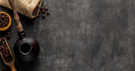 Wall Mural - Turkish coffee background with copy space. Cezve pot, overturned bag and spatula full of roasted beans