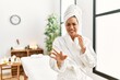 © Krakenimages.com - Young brunette woman wearing towel and bathrobe standing at beauty center disgusted expression, displeased and fearful doing disgust face because aversion reaction. with hands raised