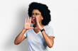 © Krakenimages.com - Young african american woman wearing casual white t shirt shouting angry out loud with hands over mouth