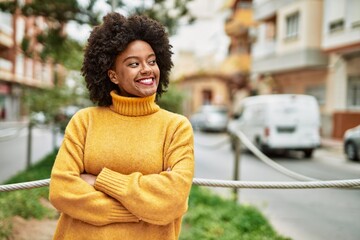 Sticker - Young african american girl smiling happy with arms crossed gesture at the city.