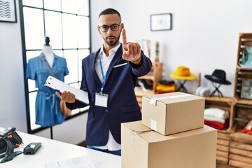 Poster - African american man working as manager at retail boutique pointing with finger up and angry expression, showing no gesture