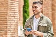 © Krakenimages.com - Young hispanic man smiling confident using smartphone at street