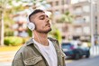 © Krakenimages.com - Young hispanic man listening to music at park