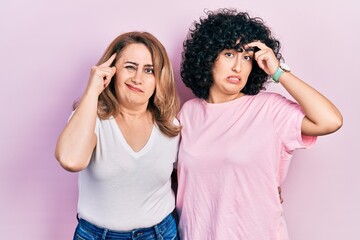 Poster - Middle east mother and daughter wearing casual clothes worried and stressed about a problem with hand on forehead, nervous and anxious for crisis