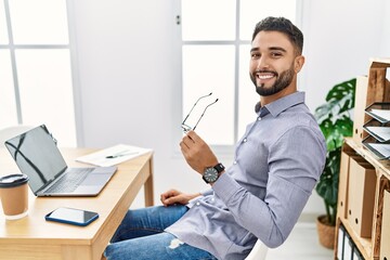 Sticker - Young arab man smiling confident using laptop working at office