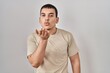 © Krakenimages.com - Young arab man wearing casual t shirt looking at the camera blowing a kiss with hand on air being lovely and sexy. love expression.