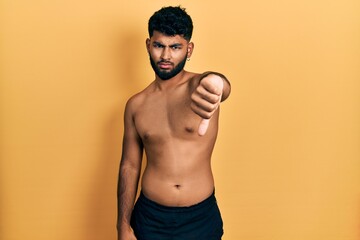 Poster - Arab man with beard wearing swimwear shirtless looking unhappy and angry showing rejection and negative with thumbs down gesture. bad expression.