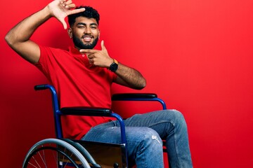 Poster - Arab man with beard sitting on wheelchair smiling making frame with hands and fingers with happy face. creativity and photography concept.