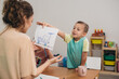 © cherryandbees - kids with their teacher drawing in kindergarden. boy shows his work