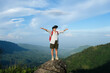 © Pornpimon - Happy adventure woman wearing vr headset augmented reality virtual reality in beautiful mountain landscape concept. Young woman using virtual reality glasses stands on a cliff on top of a mountain.
