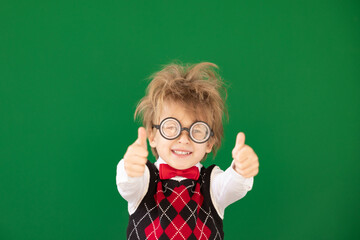 Wall Mural - Happy child in class against green chalkboard