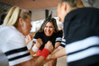 © Halfpoint - Group of young and old women in gym stacking hands together, sport team players.