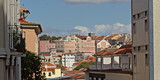 Fototapeta Miasto - Pastel colored houses and apartment buildings on a hill of Lisbon
