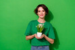 Photo of sweet funny woman wear casual t-shirt holding small plant pot isolated green color background