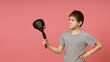 © Sergey - a boy in a gray t-shirt looks at a large funnel in his hand on a pink background