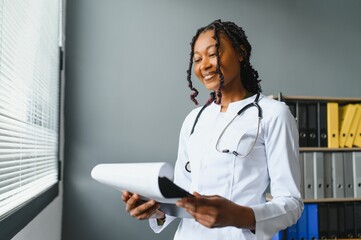 Wall Mural - happy young african female nurse working in office.