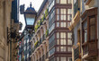 Fasada zabytkowego budynku , w tle ulica , na pierwszym planie latarnia. Bilbao