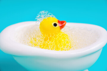 Rubber duck in a bathtub on blue