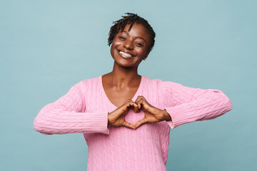 Wall Mural - African american happy woman smiling and gesturing heart-shape sign