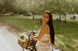 © BGStock72 - Young woman with flowers in the basket of electric bike