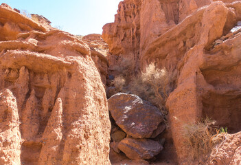 Red rocks and a passage between rocks. Clay canyons. Issyk-Kul region in Kyrgyzstan. Travel and tourism