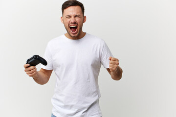 Aggressive angry tanned handsome man in basic t-shirt play difficult game with joystick gamepad posing isolated on over white studio background. Copy space Banner Mockup. Gamer RPG concept