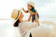 © kleberpicui - Mother and her baby son playing on the beach during summer vacation