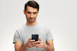 © SHOTPRIME STUDIO - handsome man in a gray t-shirt with a phone communication technology cropped view
