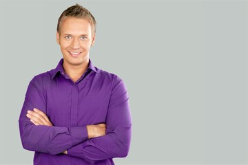 Wall Mural - Portrait of smiling mature man standing and posing on background.