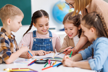 teacher helping children with schoolwork