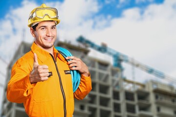 Wall Mural - Young engineer handsome man or architect with safety helmet in construction site. Standing at modern building construction.