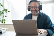 © saksit - Asian middle aged man sitting at home working on video call. Work from home concept
