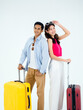© tete_escape - Couple travelers ready to trip in happy holiday. Colorful summer vacation. Young Asian woman and man in casual costume standing together with suitcases isolated on white background, vertical style.