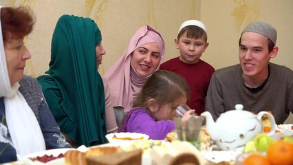 Wall Mural - Eid al-Adha Feast of the Sacrifice is the holidays which are celebrated within Islam. Happy Muslim family having dinner together