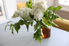 Bouquet Of White Lilacs In A Yellow Glass Vase On The Table